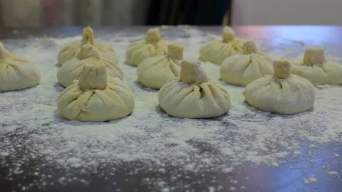 Cooked dumplings lay on the table, sprinkled with flour Stock Footage 97719496