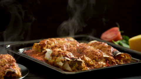 Cooked enchiladas on a black background goes steam Stock Footage 191405958