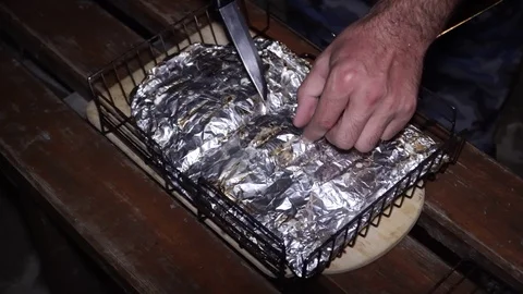 Cooked fish in foil on a wooden surface Stock Footage 101685189