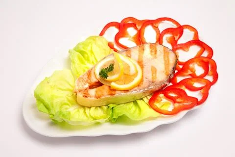 Cooked fish with lemon on salad Stock Photos