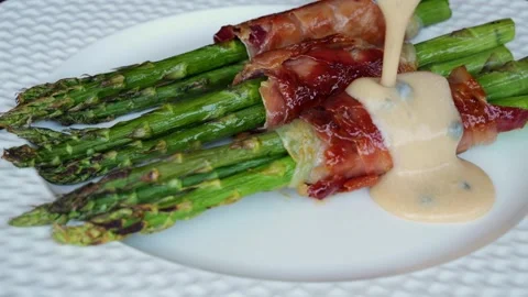 Cooked fried asparagus with jamon bacon, pouring sauce, slow motion, close up Stock Footage 245460862