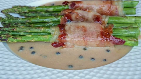 Cooked fried asparagus with jamon bacon, sauce, rotates 360 degrees, close up Stock Footage 245460952