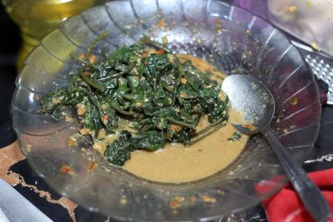 Cooked green leafy vegetables coated in rich peanut sauce served in a clear.. Stock Photos