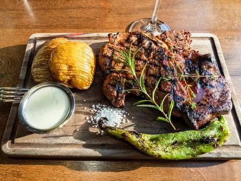 Cooked grilled t-bone beef steak on wooden board Stock Photos