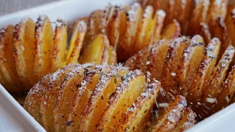 Cooked hasselback potatoes roasted in oven sprinkle parmesan cheese. Close up. Video stock 250263799