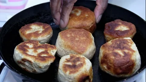 Cooked Jamaican fried dumplings being removed from a frying pan Stock Footage 171316628