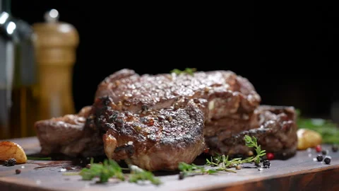 Cooked juicy steak meat beef with seasoning dropped on wooden chopping board. Stock Footage 170318225