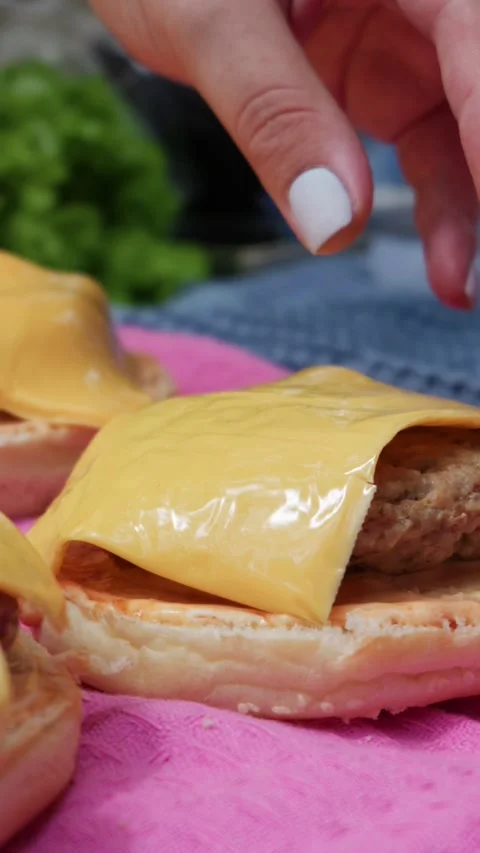 Cooked Meat Burger Patty Placed on Sauced Bun for Homemade Cheeseburger Stock Footage 342001207