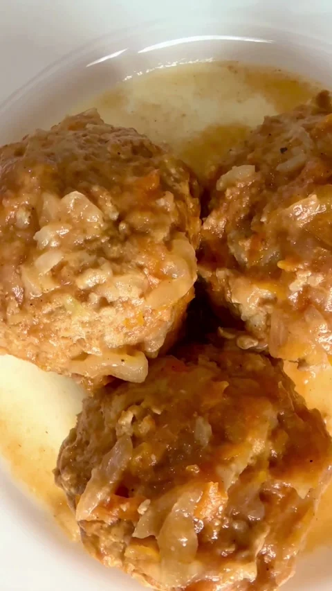 Cooked meat patties covered in thick onion sauce plate Video stock 331973758