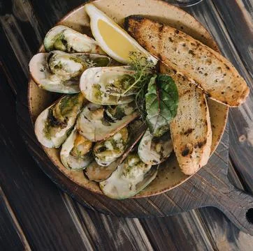 Cooked mussels in clay dish with bread Stock Photos