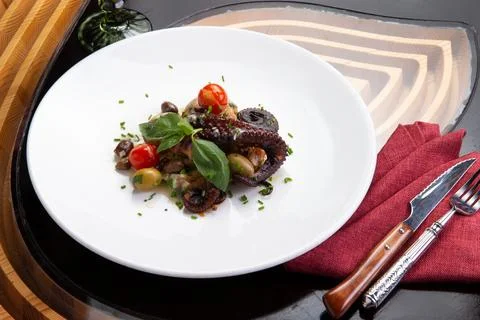 Cooked octopus tentacles in a plate. Stock Photos
