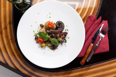 Cooked octopus tentacles in a plate. Stock Photos