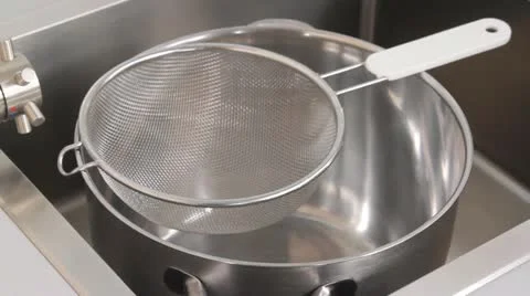 Cooked orzo pasta being poured into a sieve and quenched Stock-Footage 24656532