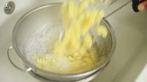 Cooked pasta being drained, slow motion. Stock Footage 162058815