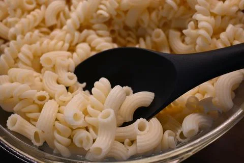 Cooked pasta close-up with serving spoon, affordable meal and cost of living con Stock Photos
