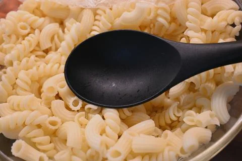 Cooked pasta close-up with serving spoon, affordable meal and cost of living con Фото
