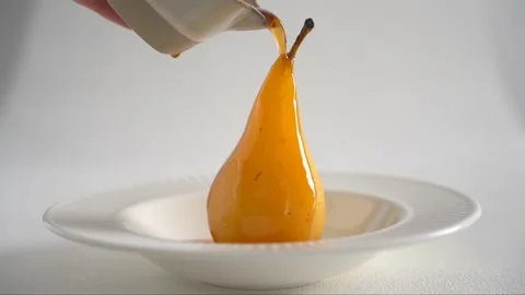 Cooked pear in wine syrup in white plate on a white background Stock Footage 168404628