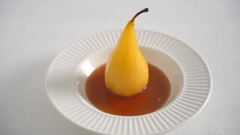 Cooked pear in wine syrup in white plate. Isolated Stock Footage 168404769