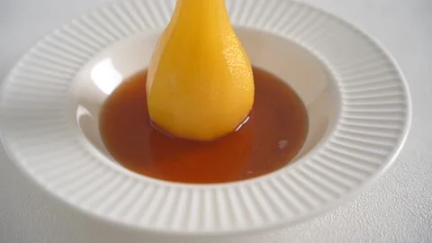 Cooked pear in wine syrup in white plate on a white background Stock Footage 168405101