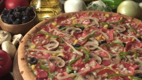 A cooked pizza with various of toppings on a decorated table Stock Footage 161525791
