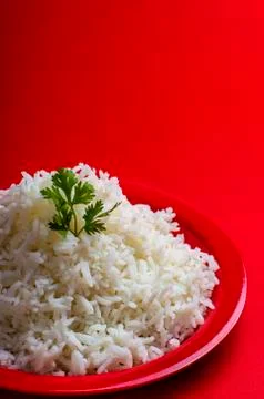 Cooked plain white basmati rice in a red plate on red background Stock Photos