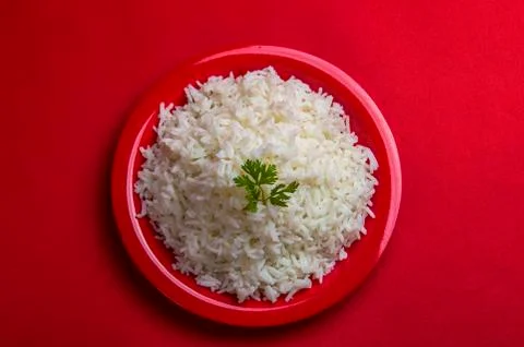 Cooked plain white basmati rice in a red plate on red background Stock Photos