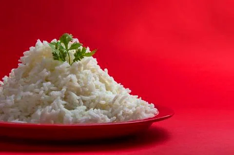 Cooked plain white basmati rice in a red plate on red background Stock Photos