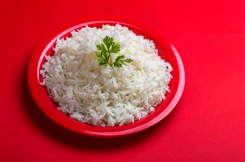 Cooked plain white basmati rice in a red plate on red background Stock Photos