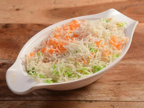 Cooked plain white basmati rice served in a bowl over rustic wooden backgroun Stock Photos