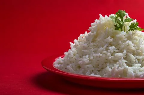 Cooked plain white basmati rice in a red plate on red background Stock Photos