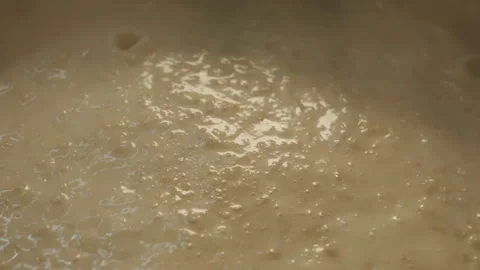 Cooked porridge boils and gurgles close-up in slow motion Stock Footage