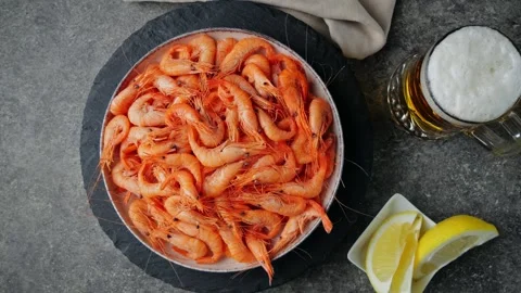 Cooked red shrimp on a plate rotating. Glass of beer. Top view Vídeos de archivo 260473881