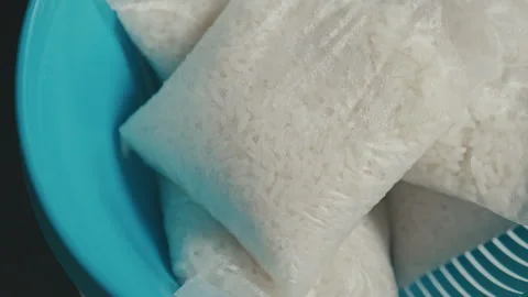 Cooked rice in a bag placed in a blue colander Stock Footage 292652814