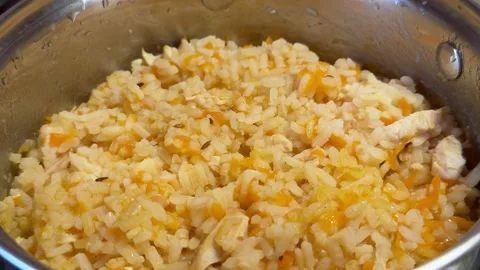Cooked rice with grated carrots and chicken pieces fills  Stock Footage 341950095