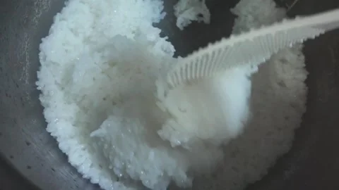 Cooked rice in a rice cooker is stirred with a spatula Stock Footage 313431153