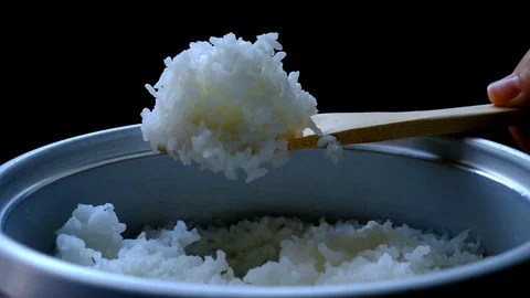 Cooked rice steaming with hand scooping  rice concept Stock Footage 103946932