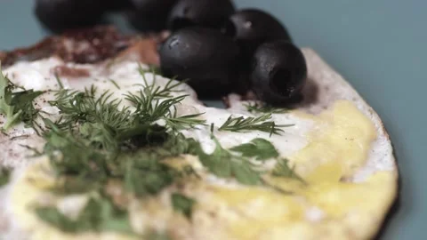 Cooked scrambled eggs with bacon slices, herbs, olives are in a large platter. Stock Footage 146334393