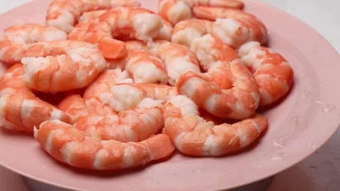 Cooked shrimp rotating in circle on pink plate for seafood recipe inspiration Stock Footage 310785798