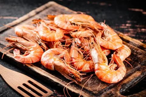 Cooked shrimp on a wooden cutting board. Stock Photos