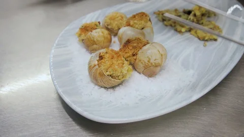 Cooked snails serving on a plate with salt and garnier. Delicious baked Stock Footage 129458294