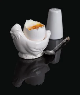 Cooked soft boiled egg, salt shaker and spoon Stock Photos