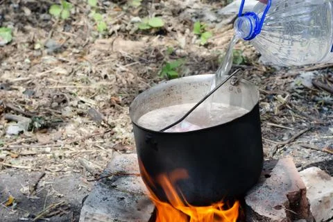 Cooked soup in a cauldron on open fire Stock Photos