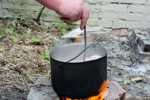Cooked soup in a cauldron on open fire Stock Photos