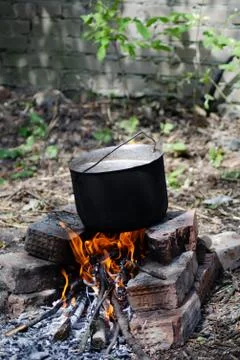 Cooked soup in a cauldron on open fire Stock Photos