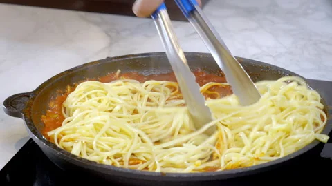Cooked spaghetti being put into the pan and mixed with hot red pasta sauce. Stock Footage 273983579