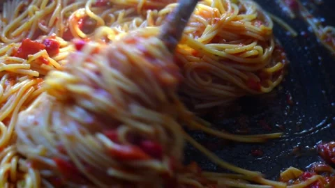 Cooked spaghetti pasta being stirred with wooden spoon in pan with tomato sauce Stock Footage 317549779