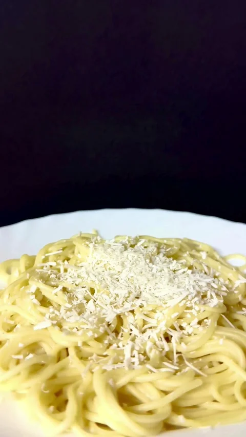 Cooked spaghetti pasta with grated cheese on white plate Video stock 331975255