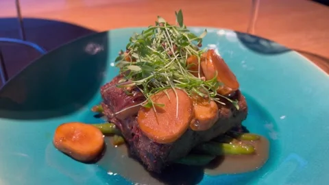 Cooked Steak with Carrot and Greens on Blue Plate Stock Footage 313164609