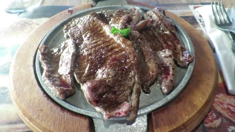 Cooked steak on heated dish Stock Footage 77597592