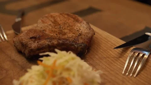 Cooked Steak on a Wooden Board with Cabbage Salad Stock Footage 137899749